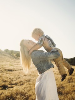 Caucasian mother and son hugging in rural field