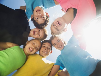 Children smiling in circle outdoors
