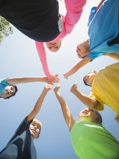 Children putting hands together outdoors