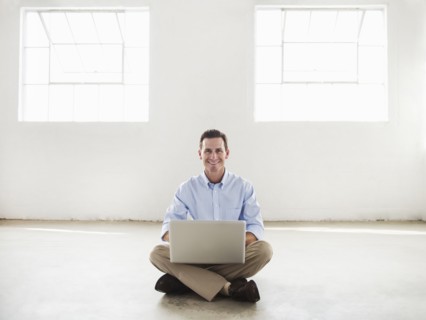 Caucasian businessman using laptop in empty office