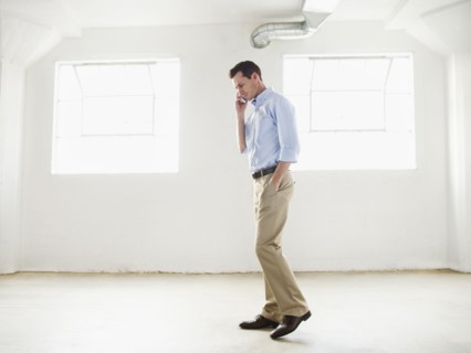 Caucasian businessman talking on cell phone in empty office
