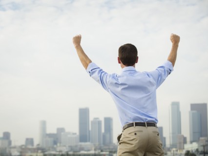 Caucasian businessman cheering on urban rooftop
