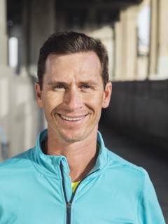 Caucasian man smiling in urban tunnel