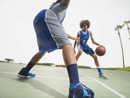 Teenage boys playing basketball on court