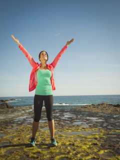 Caucasian runner stretching on beach