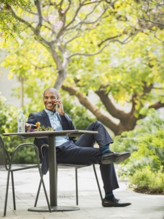 Black businessman working and eating lunch outdoors