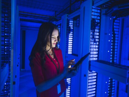 Caucasian businesswoman using digital tablet in server room