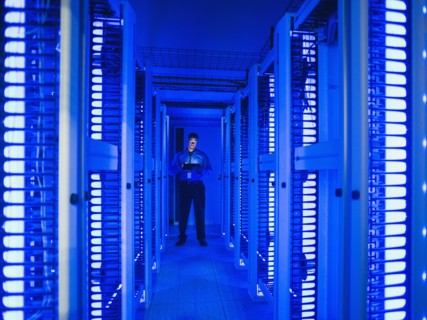 Black businessman using digital tablet in server room
