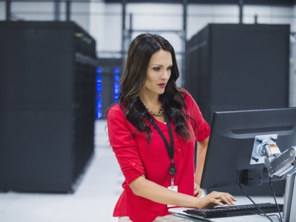 Caucasian businesswoman using computer in server room