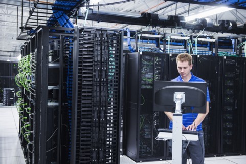Caucasian technician using computer in server room