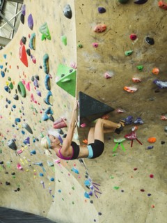 Caucasian woman climbing indoor rock wall