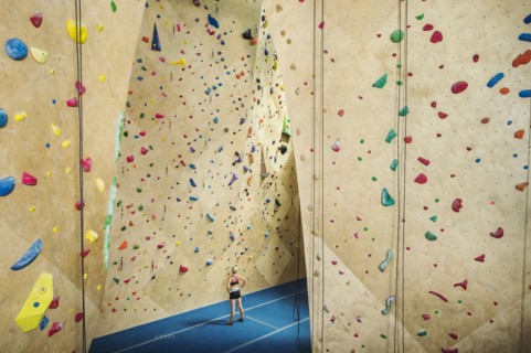 Caucasian woman examining indoor rock wall