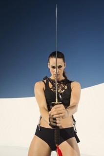Caucasian woman posing with sword