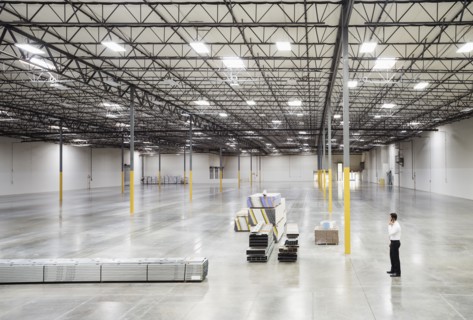 Caucasian businessman standing in empty warehouse