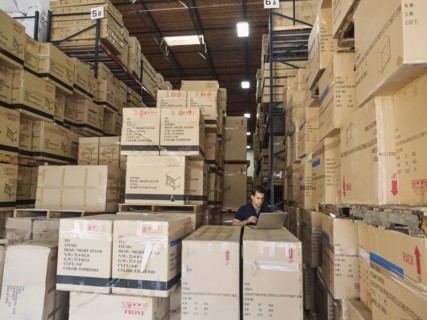 Caucasian worker using laptop in warehouse