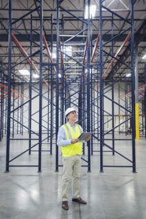 Caucasian worker using digital tablet in empty warehouse
