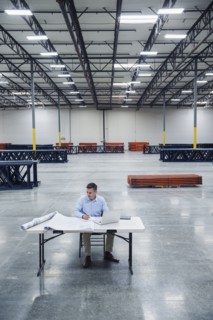 Caucasian architect reading blueprints in warehouse