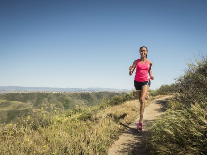 Mixed race girl running on hillside path