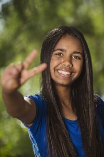 Mixed race girl giving peace sign