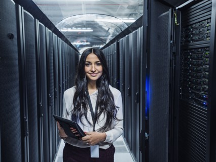 Mixed race technician holding digital tablet in server room