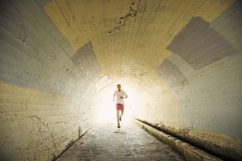 Caucasian man jogging in tunnel