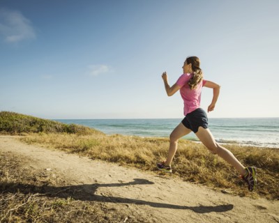 Caucasian woman jogging on beach