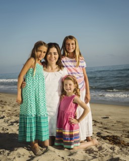 Caucasian mother and daughters smiling on beach