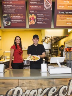 Hispanic server and businesswoman smiling in cafe
