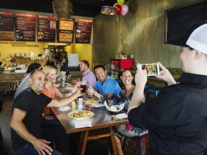 Man photographing friends in cafe