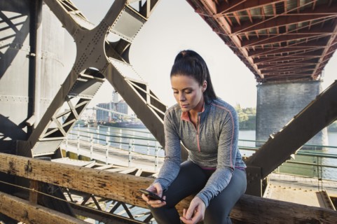 Caucasian woman sitting on urban bridge
