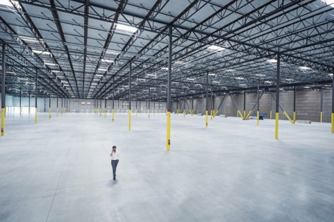 Indian businessman talking on cell phone in empty warehouse