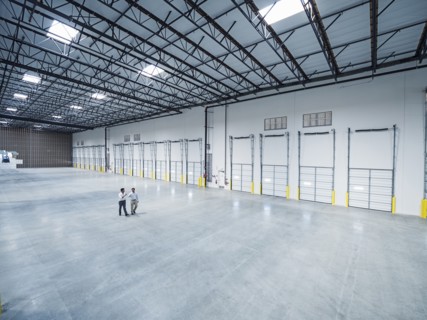Businessmen walking near loading docks in empty warehouse