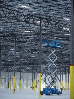 Indian worker on warehouse lift platform