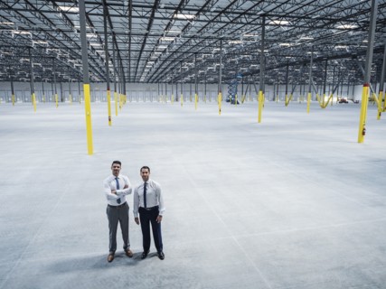 Smiling businessmen posing in empty warehouse