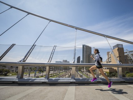 Caucasian woman running on bridge