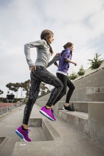 Caucasian women running on stadium staircase
