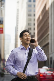 Chinese businessman talking on cell phone in city
