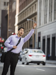 Chinese businessman hailing taxi in city
