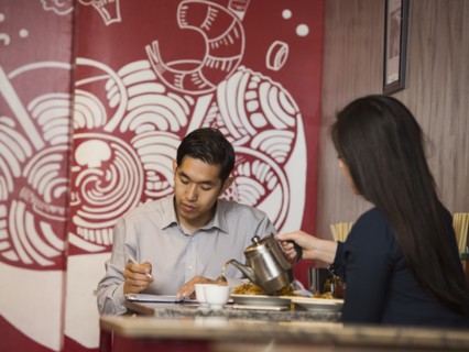 Chinese woman pouring tea in restaurant