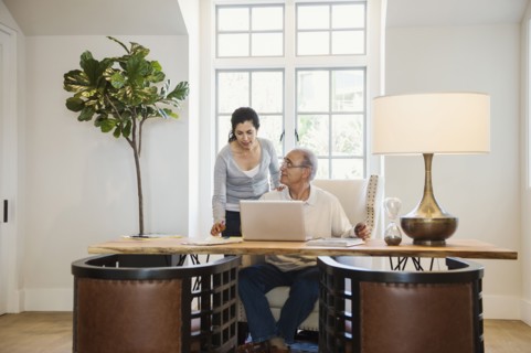 Older couple using laptop in home office