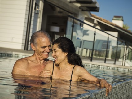 Older couple laughing in swimming pool