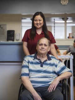 Portrait of smiling nurse and patient in wheelchair