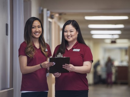 Smiling nurses holding clipboard in hospital