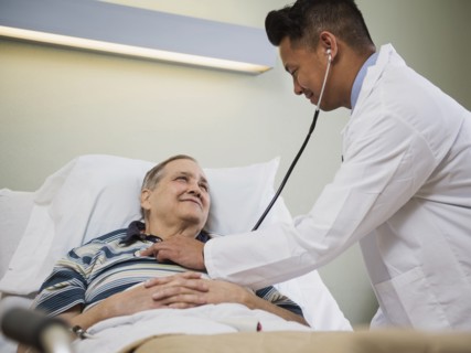 Doctor listening to chest of patient with stethoscope