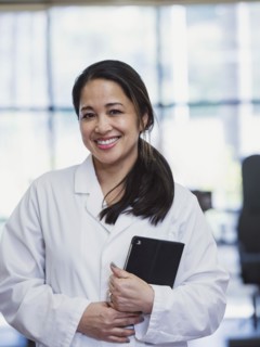 Portrait of smiling Asian physical therapist holding digital tablet