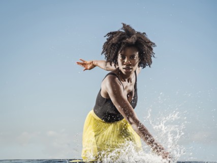 Black woman splashing in water