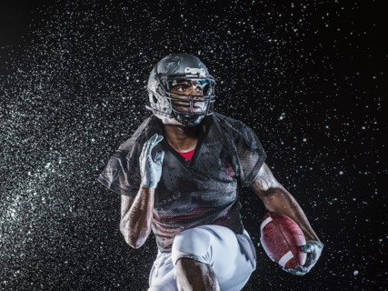 Water splashing on black football player running