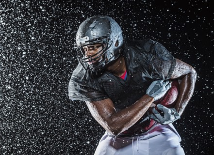 Water splashing on black football player