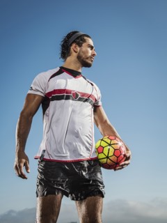 Hispanic man holding soccer ball