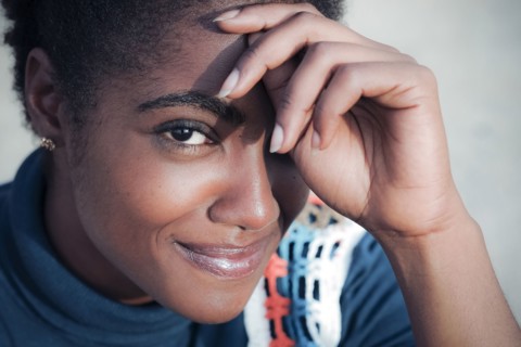 Smiling African American woman with hand on forehead